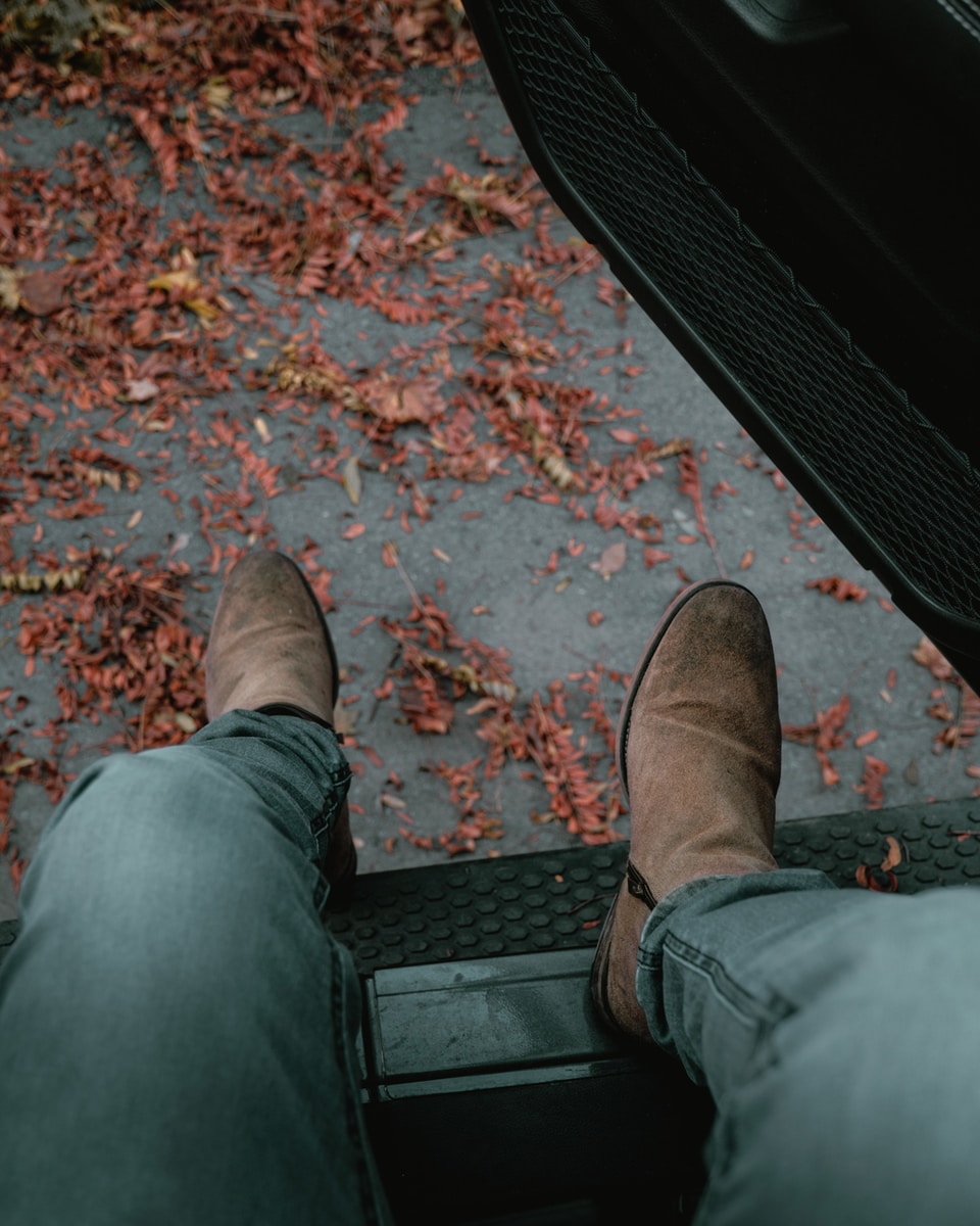 person in blue denim jeans and brown leather shoes