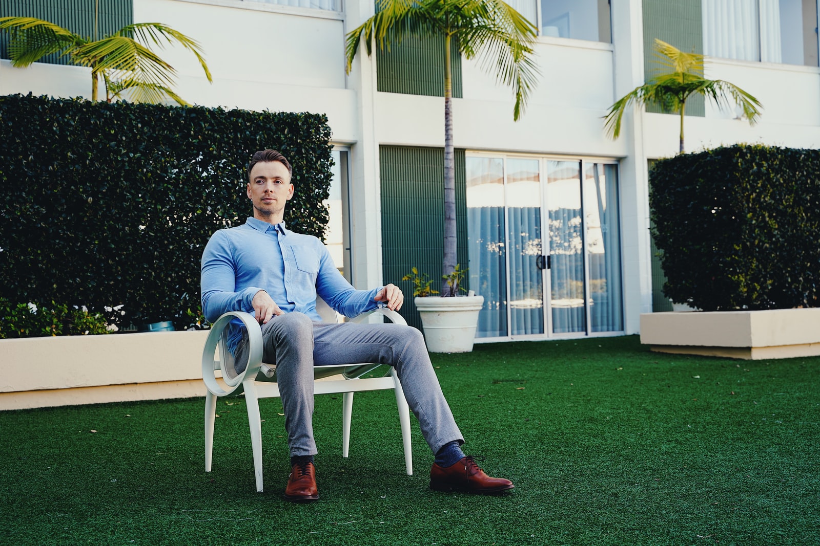 man in blue denim jeans sitting on white armchair