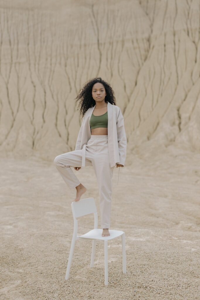 Woman Standing on Top of White Chair