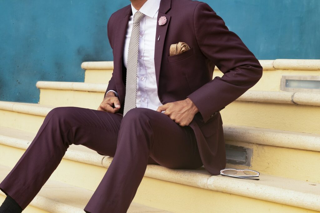 Person Sitting on Stairs Beside Sunglasses, suit