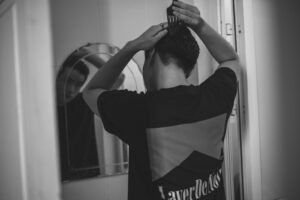 A Man Combing his Hair in Front of a Mirror