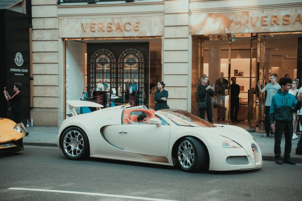 white porsche 911 parked in front of building, Versace