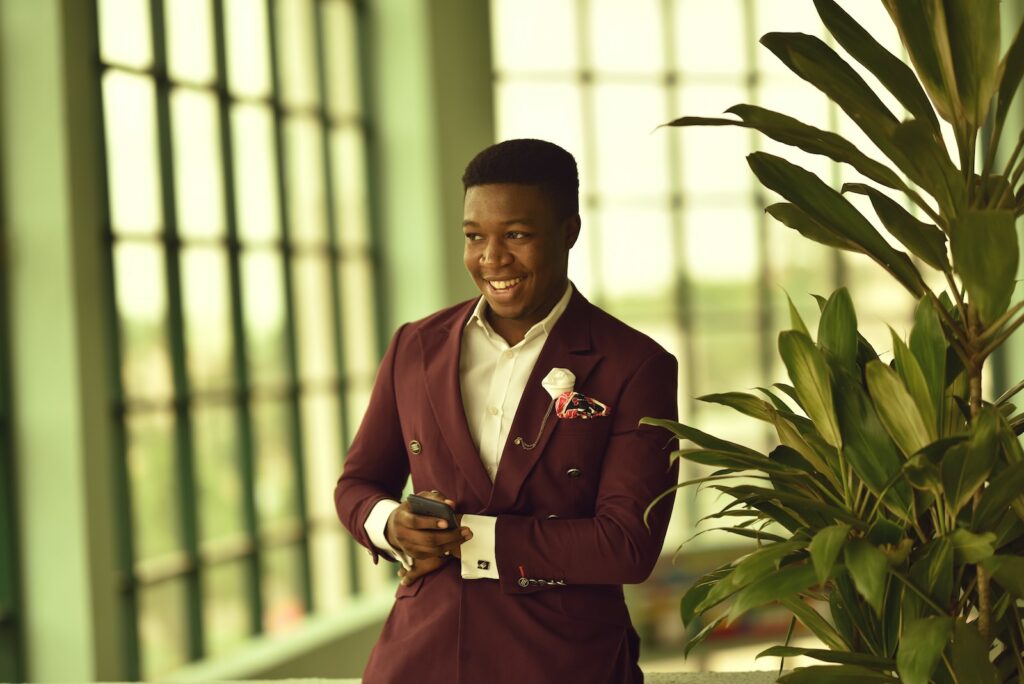 man holding smartphone while smiling, suit lapel