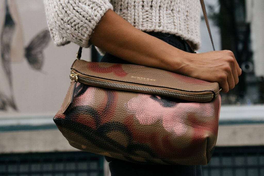 woman holding brown and pink floral leather crossbody bag, burberry