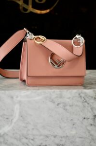 Fendi, a pink purse sitting on top of a marble counter