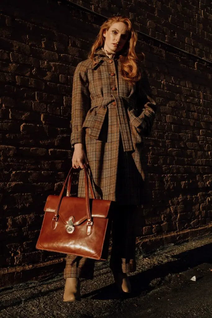 woman in brown coat holding brown leather handbag