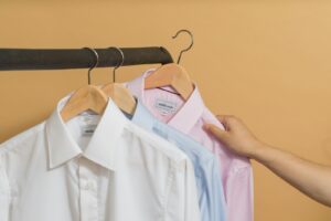 different colors of button up shirt on brown clothes hanger